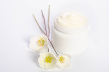 Cute flowers  and a jar of natural body cream isolated on white background