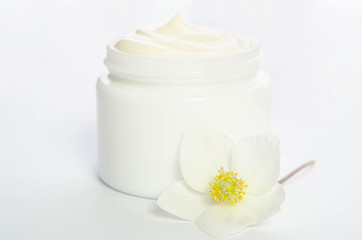 Fototapeta na wymiar Cute flower and a jar of natural body cream isolated on white background