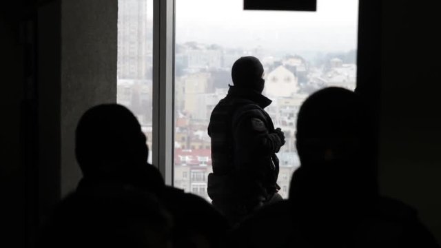 Special forces in masks blocking the entry into the office building. The police conduct a search in the office