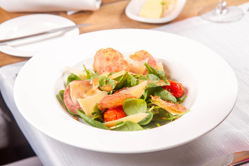 Baby spinach, dry sausage, matured cheese, roast tomatoes, thyme-balsamic vinaigrette salad served in a restaurant