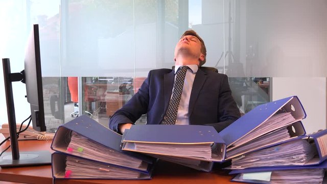 Tired overwhelmed sleeping in the office executive business person folders stack