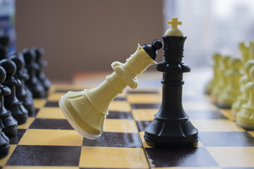 White queen and black king on a chessboard.