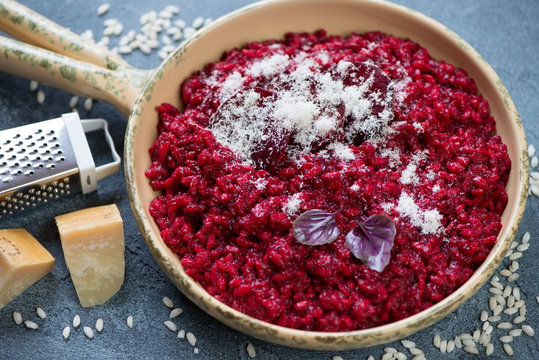 Risotto with beetroot topped with grated parmesan cheese, selective focus, studio shot