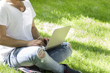 Young people using laptop in the park