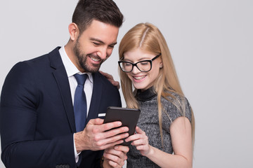 Happy young businessman and businesswoman using tablet
