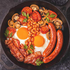 Traditional full English breakfast with fried eggs, sausages, beans, mushrooms, grilled tomatoes and bacon.