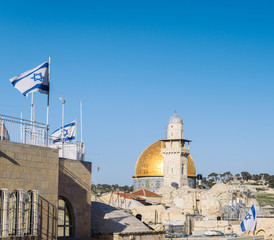 View on Dome of the Rock mosque in Jerusalem and Israeli flags from a balcony during a sunny day with copy space