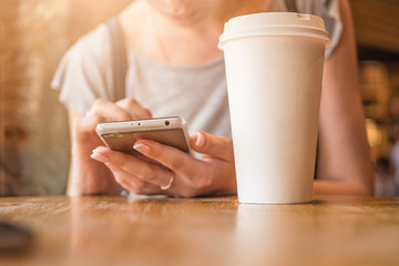 A girl is sitting with a phone in a cafe, a coffee house