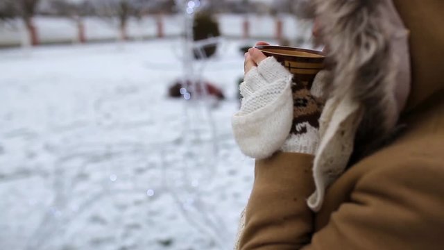 Girl drinks tea in the winter in the fresh air
