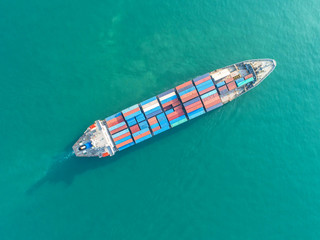 Container ship in export and import business and logistics. Shipping cargo to harbor by crane. Water transport International. Aerial view