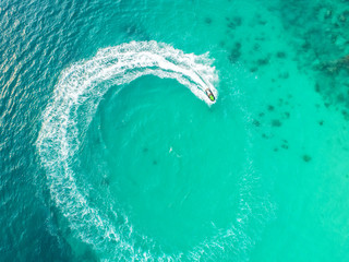 People are playing a jet ski in the sea.Aerial view. Top view.amazing nature background.The color of the water and beautifully bright. Fresh freedom. Adventure day.clear turquoise at tropical beach