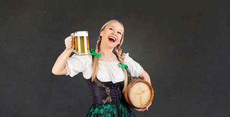 Girl waitress oktoberfest in national costume with a mug of beer in her hand.  