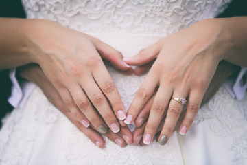 Bride & Groom make heart shape on bride's belly as a symbol of love for the up coming baby