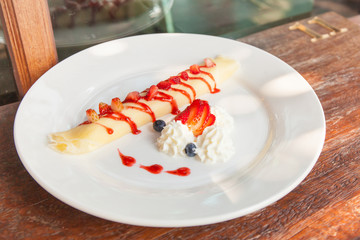 Roll Strawberry crepes with berries and cream.