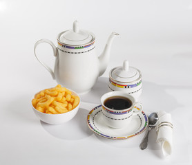 Breakfast with tea and snacks on white background.