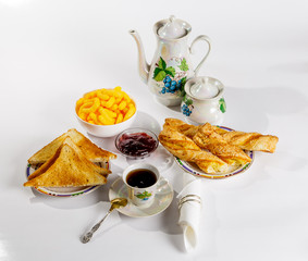 Breakfast with coffee, pastries and jam on white background