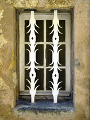 Ornamental security bars fitted to a ground floor window on a street in St Cyprien, Dordogne, Aquitane, France