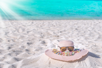 Summer time with hat and sunglass on the white sand beach background
