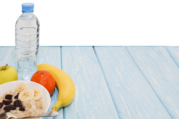 healthy breakfast. Oatmeal with raisins in a white bowl. green Apple, bananas. Flat top view. Copy space.