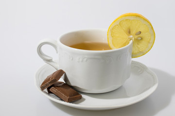 Cup of tea with chocolate and slice of lemon