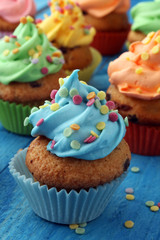 Tasty cupcakes on wooden background. Birthday cupcake in rainbow colors