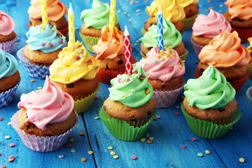 Tasty cupcakes on wooden background. Birthday cupcake in rainbow colors