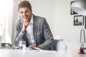 Portrait of confident young businessman working at office table