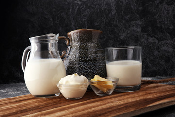 milk products - tasty healthy dairy products on a table sour cream in a bowl, cream and milk jar