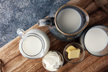 milk products - tasty healthy dairy products on a table sour cream in a bowl, cream and milk jar