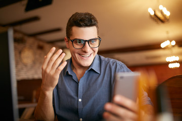 Surprised freelancer hipster man looks to smartphone and can not believe he won lottery prize or...