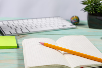 Office table desk with set of colorful supplies, flower on blue background