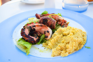 Fried octopus with fresh salad and porridge. Grilled octopus.