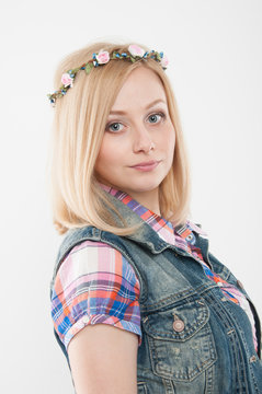Young beautiful women wearing flower wreath on her head. Spring concept. Blonde girl wearing plaid shirt and denim vest.