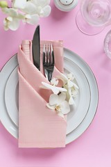 Festive table setting for Valentines Day, Easter, Mother's Day ore wedding. Elegant table decoration with fresh orchid. Overhead view with copy spase