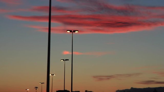 Traveling de Farolas encendidas de Autopista al Anochecer con nubes rojizas 