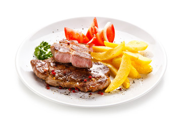 Grilled steaks, French fries and vegetables