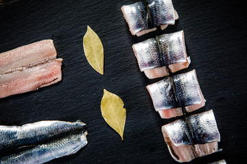 Raw herring on black stone