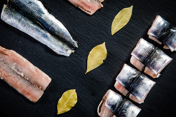 Raw herring on black stone