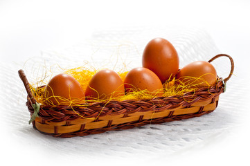 Eggs of brown chicken in a basket on a white background for Easter