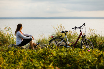 Fototapeta premium Young woman with bike at seaside