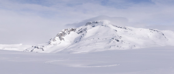 Snowy mountain with smal cloud on top