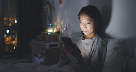 Woman use of cellphone at bedroom in the evening