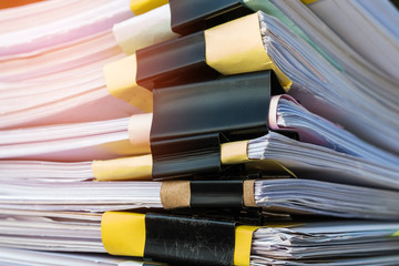 Unfinished documents stacks of paper files on office desk for report papers, piles of unfinish sheet achieves with clips. Document is written presented. Business offices busy concept.