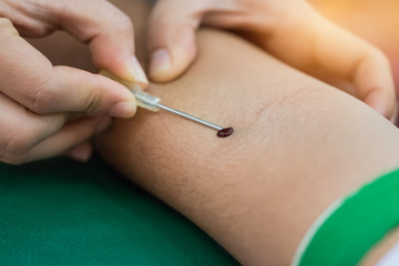 Health and Medical concept. Closeup Hands nurse are using needle to pierce vein bleeding Preparation for blood test. Blood donation occurs when person voluntarily has blood drawn used for transfusions