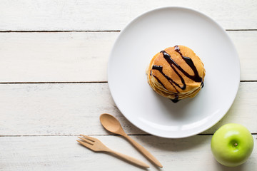 Delicious pancakes with apple on white  wooden table top view