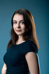 Fototapeta premium Attractive woman with big eyes wearing un black t-shirt on blue grey background