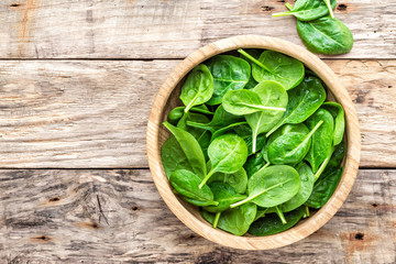 Fresh baby spinach leaves in bowl on wooden background - 191760522