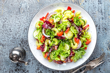 Fresh vegetable Salad of cucumber, celery, sweet pepper, frize lettuce, red onion and sesame seeds with olive oil. Healthy vegetarian, vegan food