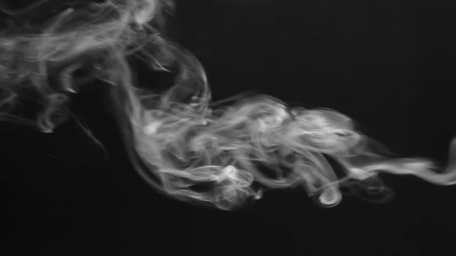 Steam clubs and smoke rings on a black background.
