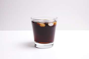 A glass of hot or soft drink with ice block in it, Cheers